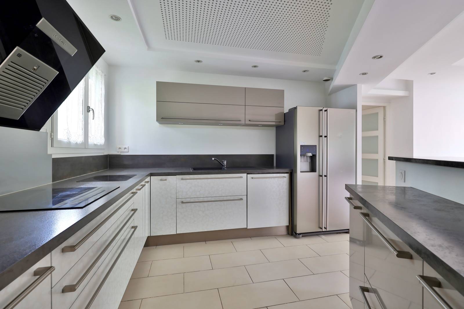 Cuisine moderne ouverte sur la pièce de vie avec nombreux rangements et plan de travail spacieux – espace convivial et lumineux dans maison familiale à Vaulx-en-Velin