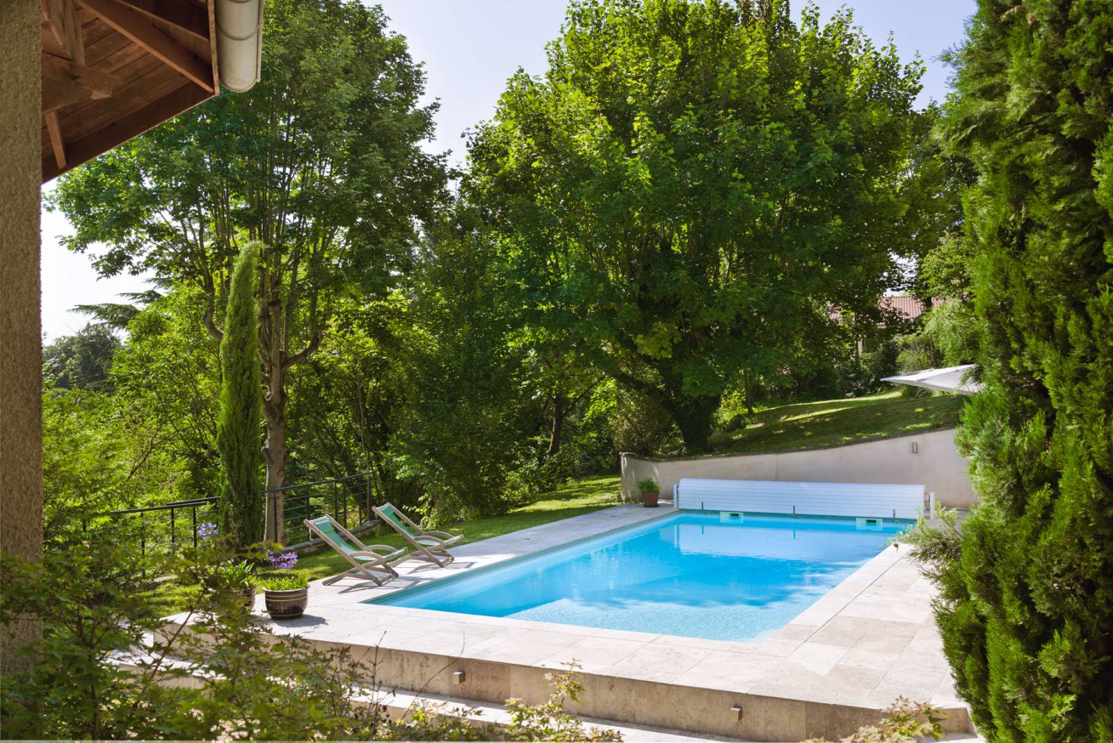 piscine dans la verdure avec plage travertin