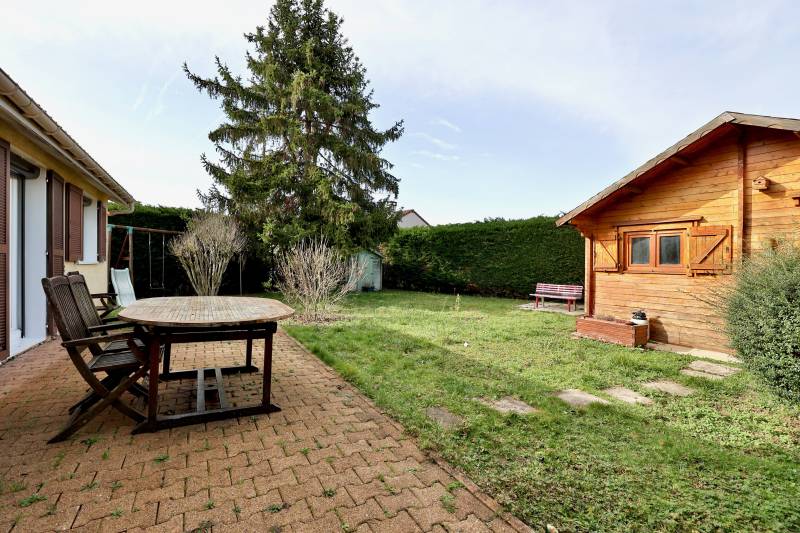 Côté jardin : une terrasse + chalet en bois posé sur dalle béton qui permet de profiter des journées un peu fraiches et donne plus de rangements
