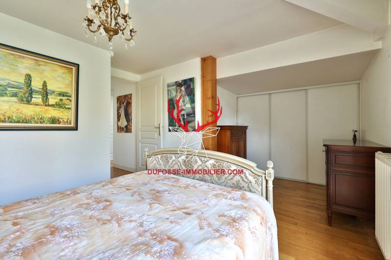 Chambre confortable en parquet dotée d'un balcon et de rangements sur mesure