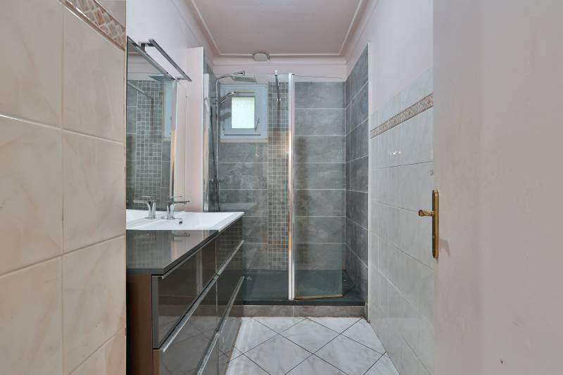 Salle d’eau du 1er étage récemment rénovée avec douche à l’italienne, meuble avec vasque et fenêtre apportant une lumière naturelle