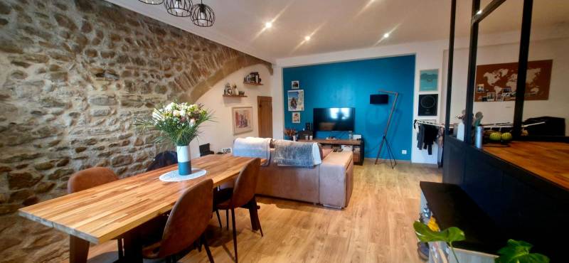 Belle pièce de vie de  avec mur en pierres