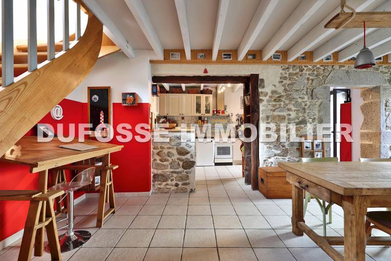 Salle à manger vue cuisine poutres et pierres apparentes