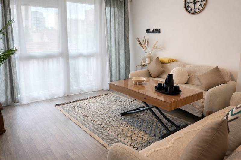 Séjour lumineux avec grande baie vitrée et balcon exposé Ouest donnant sur le jardin de la copropriété, offrant une belle luminosité naturelle en fin de journée.